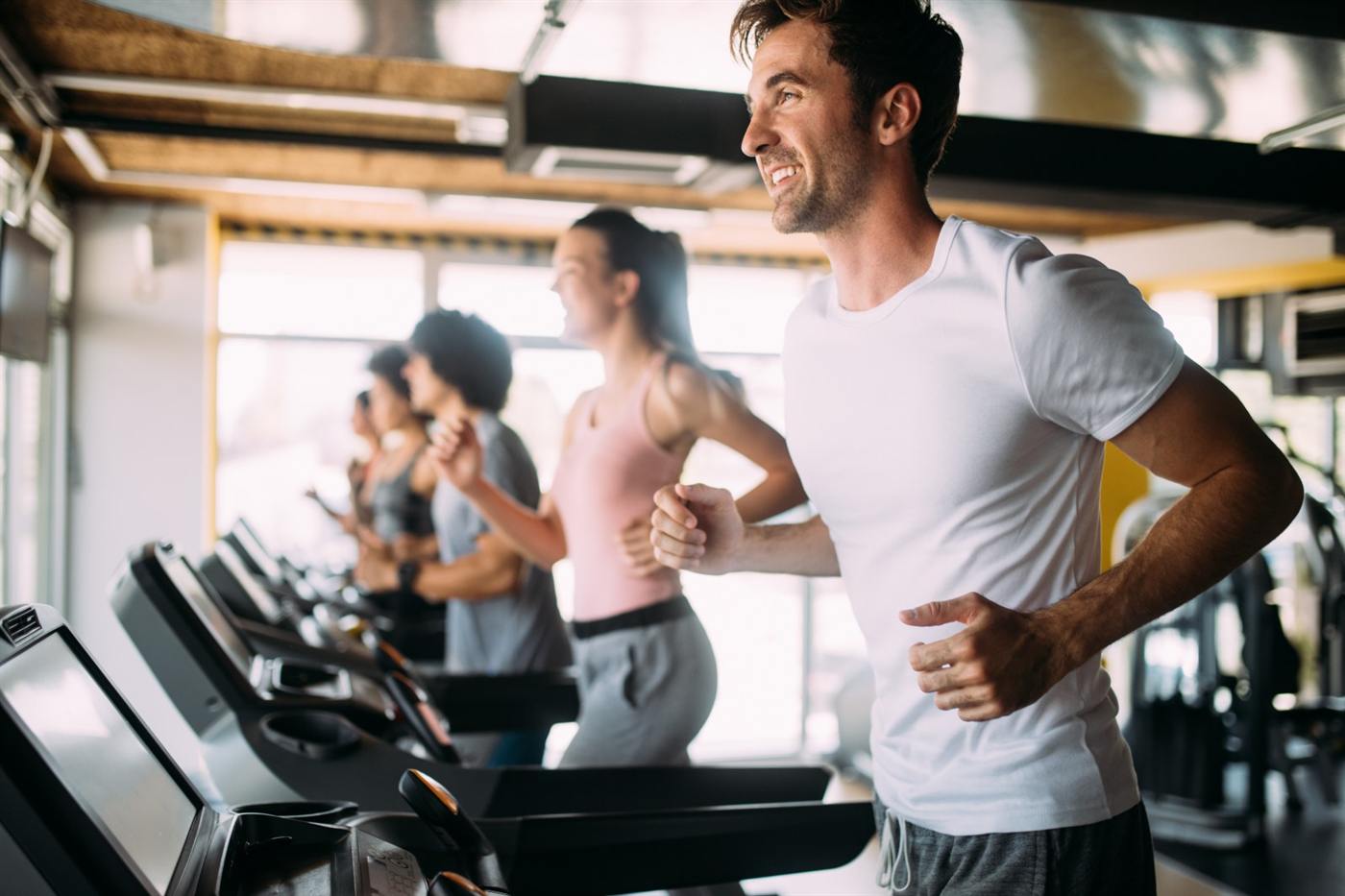 Mensen trainen op loopbanden in een sportschool